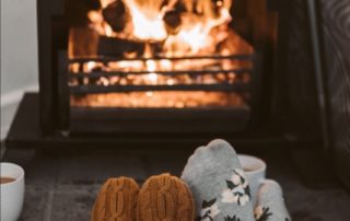 A family sitting near a fireplace wearing socks.