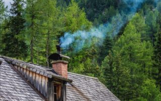 A wooden rooftop with smoke coming out of the chimney