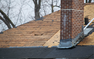 Discolored chimney and damaged roofing
